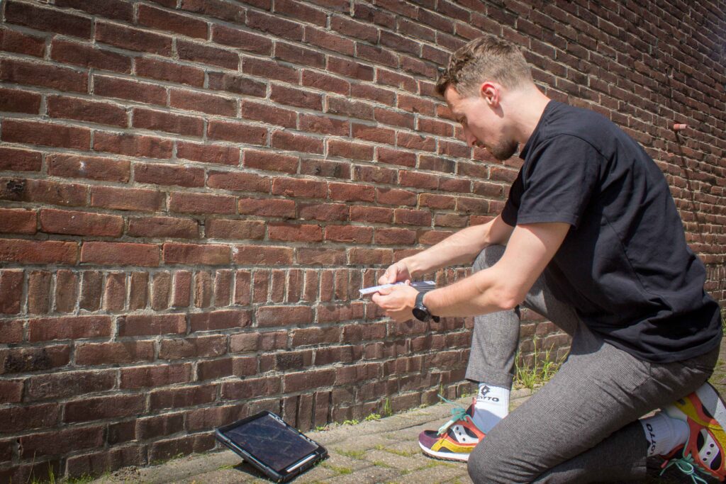 Meten van spouwdikte door energieadviseur Een energieadviseur die de spouwdikte opmeet